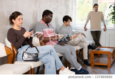 Group of of different ages in the office while waiting for an interview. Specialists, men and women in search of job are waiting for an interview in prestigious company 137869880