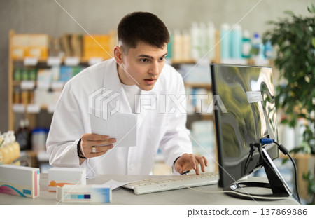 Male pharmacist with medical prescription in pharmacy Male pharmacist with medical prescription in pharmacy 137869886