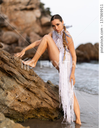 Barefoot girl on seashore in sexy and revealing Aztec carnival costume Barefoot girl on seashore in sexy and revealing Aztec carnival costume 137869911
