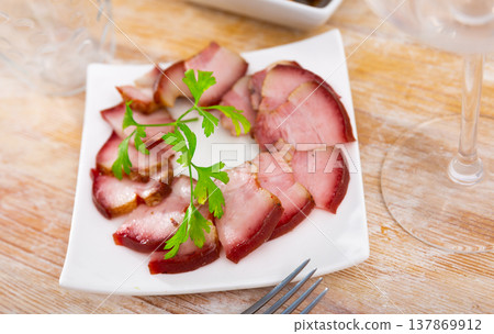 Delicious smoked lard, sliced with greens on white plate 137869912