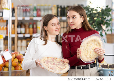 Teenage girl and her mother choosing pizza in grocery store Teenage girl and her mother choosing pizza in grocery store 137869924
