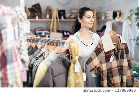 Armenian woman trying on a plaid jacket in a store Armenian woman trying on a plaid jacket in a store 137869950