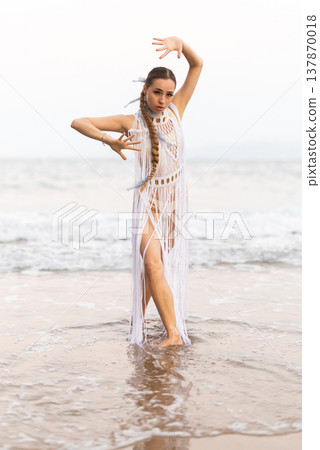 Barefoot girl on seashore in sexy and revealing Amazon tribe carnival costume. 137870018
