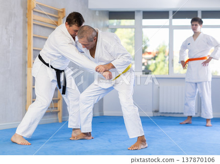 Adult and elderly men training judo fight Adult and elderly men training judo fight 137870106
