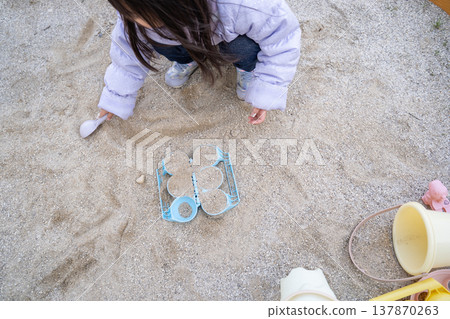 A girl playing in a sandbox A girl playing in a sandbox 137870263