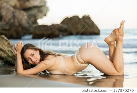 Naked young girl in bikini panties is on knees and elbows. Naked young girl in bikini panties is on knees and elbows. 137870270