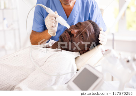 African American experiencing facial skin peeling using ultrasonic scrubber African American experiencing facial skin peeling using ultrasonic scrubber 137870295