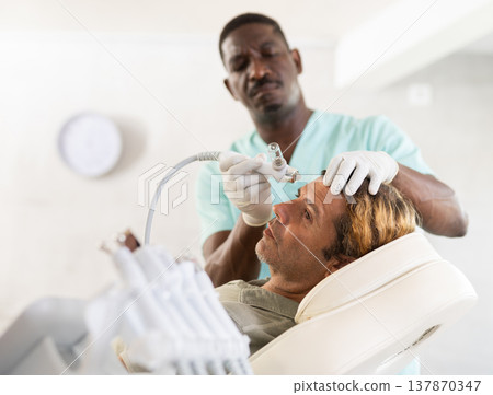 Adult man undergoing facial procedure with application of atomized nutrients Adult man undergoing facial procedure with application of atomized nutrients 137870347