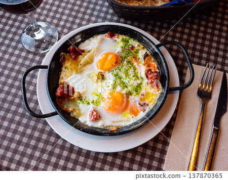 Traditional Riojan eggs with potatoes and sausages in iron pan Traditional Riojan eggs with potatoes and sausages in iron pan 137870365