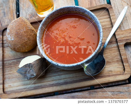 Bowl of tomato soup served on wooden board 137870377