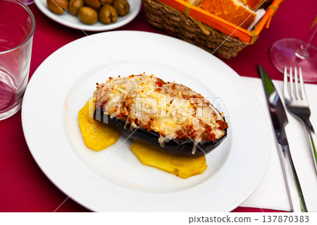Grilled stuffed eggplant with slices of baked potato Grilled stuffed eggplant with slices of baked potato 137870383