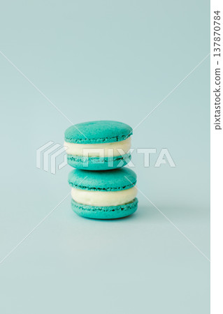 Two French macarons on a light blue background. Mint macarons. Two French macarons on a light blue background. Mint macarons. 137870784