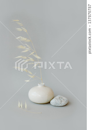 Still life with dry spikelets of wild oats and stones. Grey background. Still life with dry spikelets of wild oats and stones. Grey background. 137870787