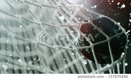 An ice hockey puck hitting the back of the net as it scores a goal An ice hockey puck hitting the back of the net as it scores a goal 137870888