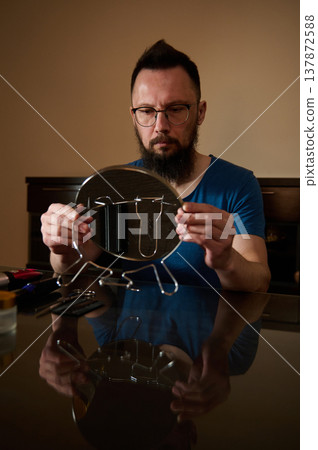 Bearded Man Examining Mirror While Preparing Personal Grooming Tools At Table Bearded Man Examining Mirror While Preparing Personal Grooming Tools At Table 137872588