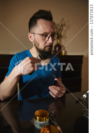 Man Grooming Beard With Electric Trimmer At Home Bathroom Table Routine Man Grooming Beard With Electric Trimmer At Home Bathroom Table Routine 137872613