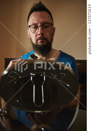 Man Trimming Beard With Electric Trimmer While Looking Into Mirror At Home Man Trimming Beard With Electric Trimmer While Looking Into Mirror At Home 137872614