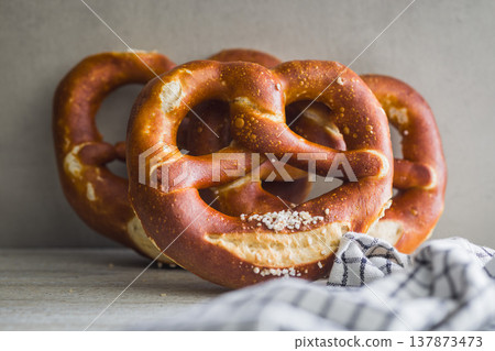 Fresh Soft Pretzels on Striped Cloth . Golden Baked Salted Snack for Breakfast or Picnic 137873473