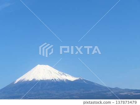 Snow-covered Mount Fuji against a blue sky: A winter scene in Japan 137873479