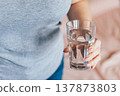 World Water Day. Woman holds glass of clean water in her hands. Health care concept. Drinking water in morning to boost metabolism. 137873803