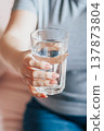 World Water Day. Woman holds glass of clean water in her hands. Health care concept. Drinking water in morning to boost metabolism. 137873804