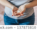 Womans hand is holding pills. Overdose of medicinal capsules in palms close-up. 137873810