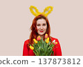Young woman wearing bunny ears holding bouquet of tulips. Easter concept 137873812