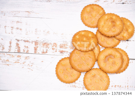 Close-up of a round cracker superimposed on a wood grain background. Close-up of a round cracker superimposed on a wood grain background. 137874344
