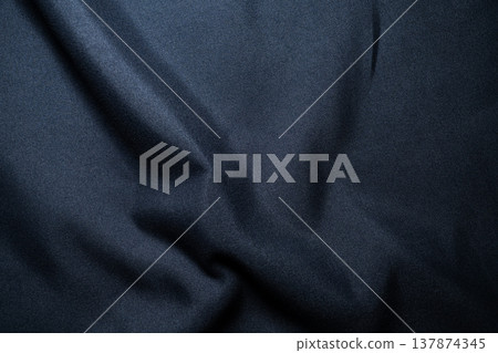 Textile background with wrinkles spreading across black fabric Textile background with wrinkles spreading across black fabric 137874345
