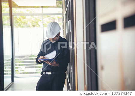Man construction engineer writing note wear blue shirt safety white hard hat at construction site. Industry labour male worker. Architecture man drawing engineer civil constrcution real estate Man construction engineer writing note wear blue shirt safety white hard hat at construction site. Industry labour male worker. Architecture man drawing engineer civil constrcution real estate 137874347