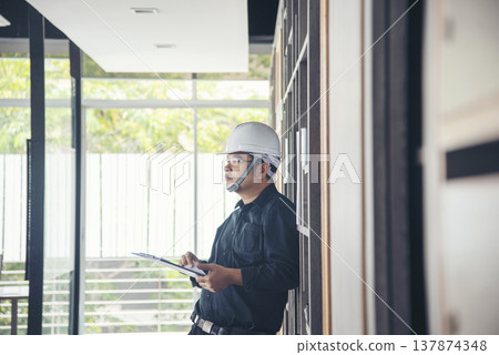 Man construction engineer writing note wear blue shirt safety white hard hat at construction site. Industry labour male worker. Architecture man drawing engineer civil constrcution real estate Man construction engineer writing note wear blue shirt safety white hard hat at construction site. Industry labour male worker. Architecture man drawing engineer civil constrcution real estate 137874348