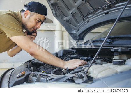 Men fix car call for help use phone calling insurance agent help fixing car problem breakdown. Man calling mechanic car service technician support fix repair driving. Vehicle emergency problem Men fix car call for help use phone calling insurance agent help fixing car problem breakdown. Man calling mechanic car service technician support fix repair driving. Vehicle emergency problem 137874373