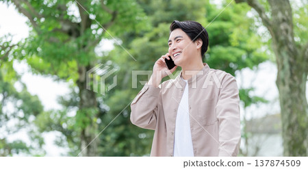 A man talking on his smartphone outdoors A man talking on his smartphone outdoors 137874509