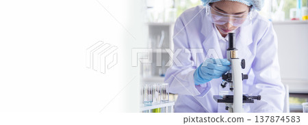 Banner Asian woman scientist hand write note research in medical lab look at science microscope. Panorama biology chemistry lab. Asian Female technician laboratory using microscope with copy space Banner Asian woman scientist hand write note research in medical lab look at science microscope. Panorama biology chemistry lab. Asian Female technician laboratory using microscope with copy space 137874583