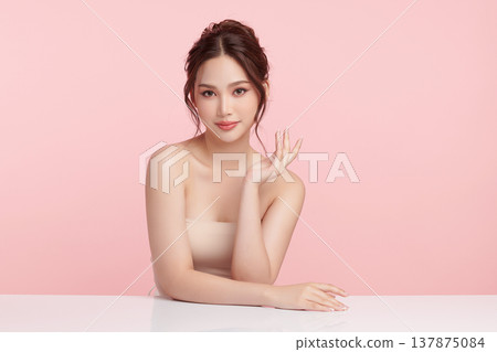 A beautiful young Asian woman with clean, fresh skin against a pink background. Skincare, facial treatment, cosmetology, beauty, and spa. An elegant portrait of an Asian woman. A beautiful young Asian woman with clean, fresh skin against a pink background. Skincare, facial treatment, cosmetology, beauty, and spa. An elegant portrait of an Asian woman. 137875084