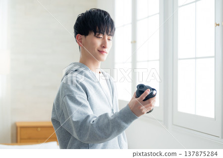 一名男子拿著蛋白粉搖杯 一名男子拿著蛋白粉搖杯 137875284