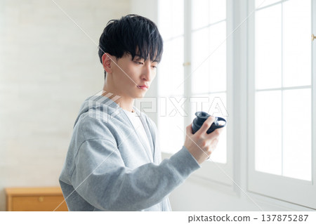 一名男子拿著蛋白粉搖杯 一名男子拿著蛋白粉搖杯 137875287