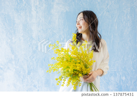 Woman holding a bouquet of mimosa Woman holding a bouquet of mimosa 137875431