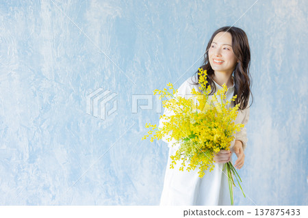 Woman holding a bouquet of mimosa 137875433