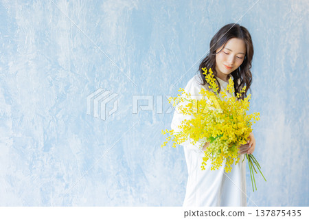 Woman holding a bouquet of mimosa 137875435