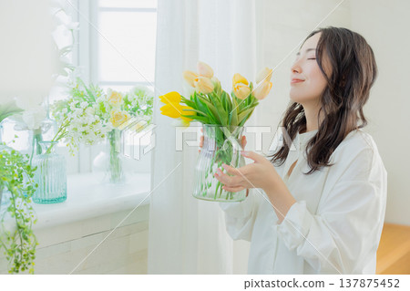A woman holding a vase of tulips 137875452