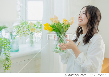 A woman holding a vase of tulips 137875453