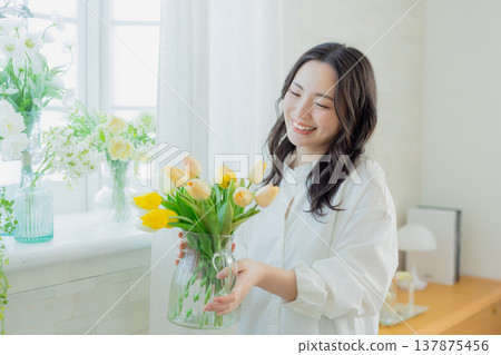 A woman holding a vase of tulips 137875456