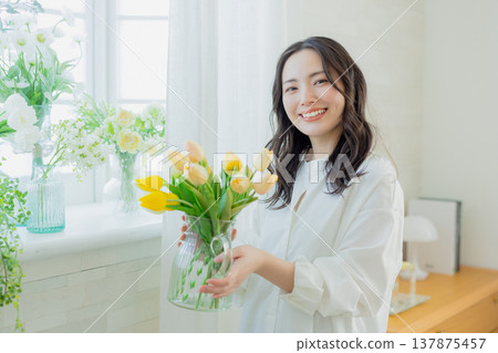 A woman holding a vase of tulips 137875457