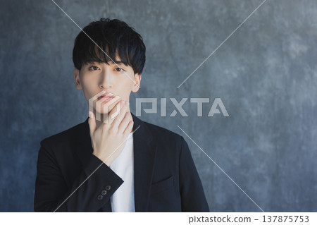 微笑一個年輕的人看照相機 微笑一個年輕的人看照相機 137875753