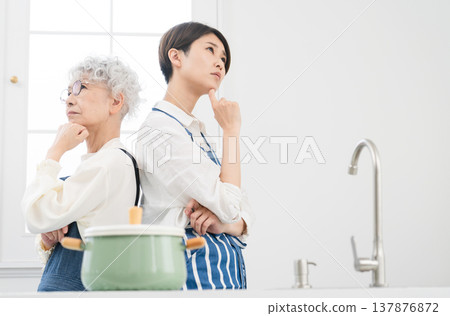Young woman and senior woman standing in the kitchen Cooking image Young woman and senior woman standing in the kitchen Cooking image 137876872