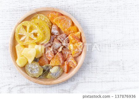 A plate of dried fruit against a white wood grain background. A plate of dried fruit against a white wood grain background. 137876936