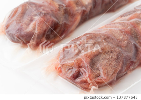 Close-up of a thick slice of frozen beef tongue in a pack. 137877645