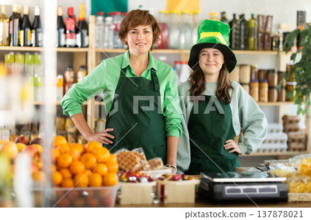 Two female shop assistants in green shirt and hat on Irish holiday St Patrick Day Two female shop assistants in green shirt and hat on Irish holiday St Patrick Day 137878021