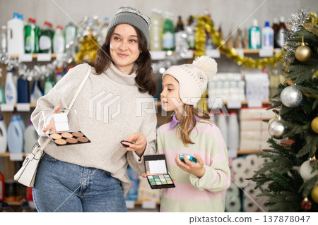 Woman with daughter choosing cosmetics in decorated store Woman with daughter choosing cosmetics in decorated store 137878047